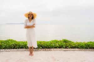 Portrait beautiful asian woman wear hat with smile happy leisure on the beach and sea in holiday vacation photo