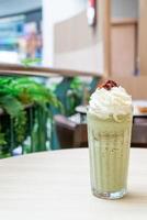 Latte de té verde matcha mezclado con crema batida y frijoles rojos en la cafetería, cafetería y restaurante foto