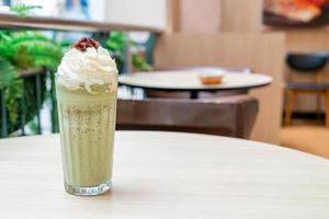 Matcha green tea latte blended with whipped cream and red bean in coffee shop cafe and restaurant photo