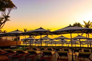 Umbrellas and chairs around outdoor swimming pool in hotel resort for holiday vacation travel background photo