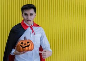 Hombre sujetando calabazas naranjas en la noche de halloween foto