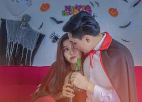 Young couple having fun drinking and celebrating the Halloween party photo