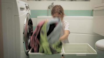 uma mulher separa a roupa antes de lavar