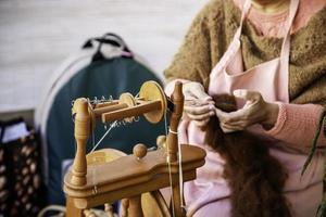 Spinning with a wooden spinning wheel photo