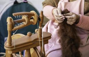 Spinning with a wooden spinning wheel photo