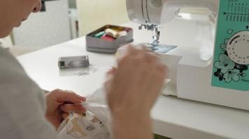 una costurera trabaja en una máquina de coser