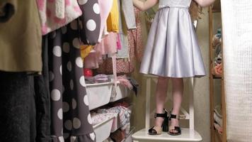 hermosa niña elige vestido de su armario de casa. belleza y moda video