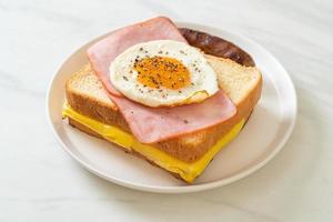 pan casero, queso tostado, jamón cubierto y huevo frito con salchicha de cerdo para el desayuno foto