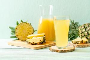 Fresh pineapple juice on wood background photo