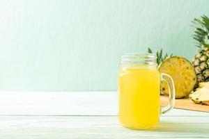 Fresh pineapple juice on wood background photo