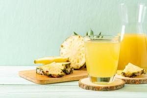 Fresh pineapple juice on wood background photo