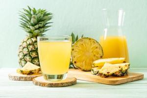 Fresh pineapple juice on wood background photo