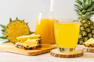 Fresh pineapple juice on wood background photo