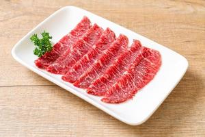 Carne fresca cruda en rodajas con textura de mármol servida para sukiyaki y shabu o yakiniku foto