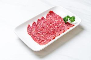 Fresh beef raw sliced with marbled texture served for Sukiyaki and Shabu or Yakiniku photo