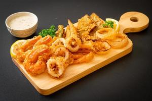 mariscos, camarones y calamares fritos con vegetales mixtos - estilo de comida poco saludable foto