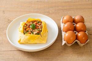 Egg wrap or stuffed egg with minced pork, carrot, tomato, and green peas photo