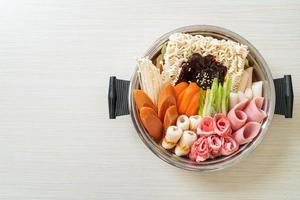 Budae Jjigae or Budaejjiga, Army stew or Army base stew. It is loaded with Kimchi, spam, sausages, ramen noodles and much more - popular Korean hot pot food style photo