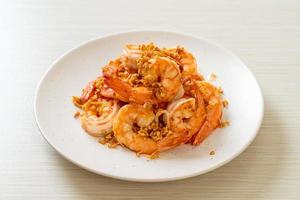 Fried shrimps or prawns with garlic on white plate - seafood style photo