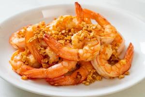 Fried shrimps or prawns with garlic on white plate - seafood style photo