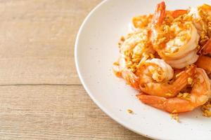 Fried shrimps or prawns with garlic on white plate - seafood style photo