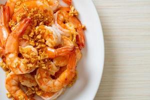 Fried shrimps or prawns with garlic on white plate - seafood style photo