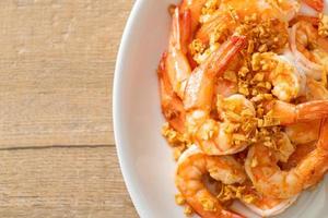 Fried shrimps or prawns with garlic on white plate - seafood style photo