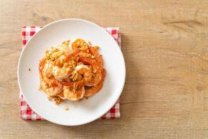 Camarones fritos o gambas con ajo en un plato blanco - estilo marisco foto