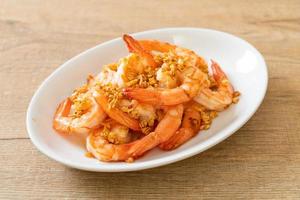 Fried shrimps or prawns with garlic on white plate - seafood style photo