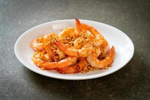 Fried shrimps or prawns with garlic on white plate - seafood style photo