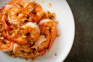 Fried shrimps or prawns with garlic on white plate - seafood style photo