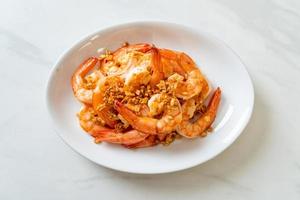 Fried shrimps or prawns with garlic on white plate - seafood style photo