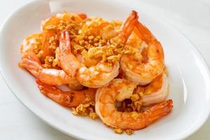 Fried shrimps or prawns with garlic on white plate - seafood style photo