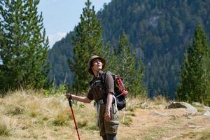 Young woman traveler with backpack in the mountains photo