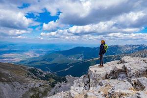 Young woman traveler with backpack in the mountains photo