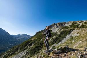 Young woman traveler with backpack in the mountains photo