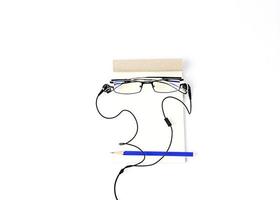 Creative idea Men face with Eyeglasses and blue pencil and Notepad with ear phone photo