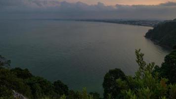 timelapse d'un lever de soleil nuageux sur la mer, vue de dessus d'une colline video