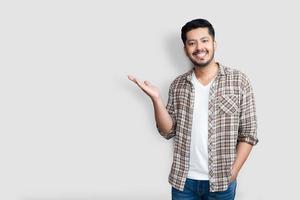 Adult Asian man over isolated background smiling cheerful presenting and pointing with palm of hand looking at the camera. photo