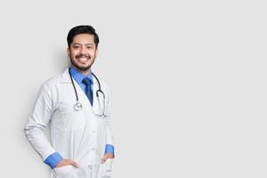 Young doctor male hands in the pocket over isolated background smiling photo