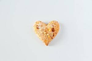 Una galleta en forma de corazón sobre un fondo blanco. foto