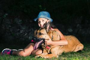 A little girl hugs her German shepherd dog photo