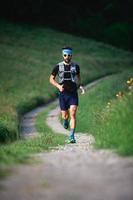 Hombre con barba atleta corriendo en las montañas durante un entrenamiento foto