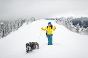 A dog and his mistress alone in the mountains with lots of snow photo
