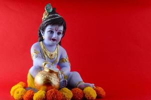 Dios hindú Krishna sobre fondo rojo. foto