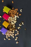 Healthy Mix Dry Fruits and Nuts on dark background. Almonds, Pistachio, Cashews, Raisins photo