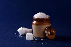 Sugar. white granulated sugar and refined sugar on a blue background photo