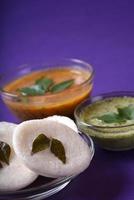 Idli with Sambar and coconut chutney on violet background, Indian Dish south Indian favourite food rava idli or semolina idly or rava idly, served with sambar and green chutney. photo