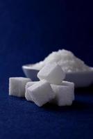 Sugar Cubes with Sugar in white plate on blue background photo