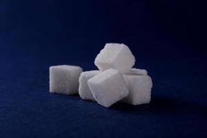 Close-up de terrones de azúcar sobre fondo azul. foto
